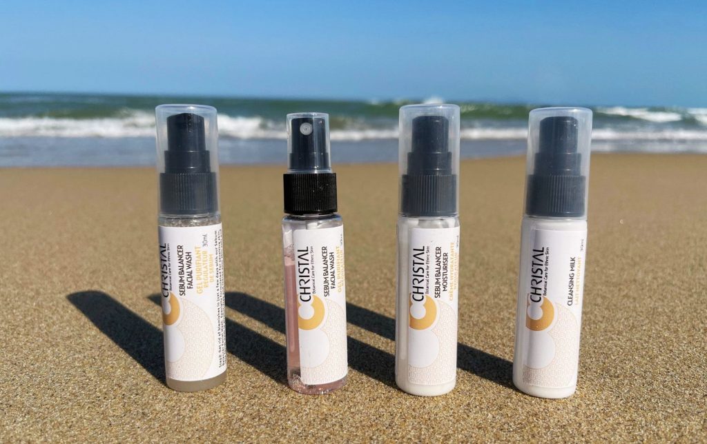 The Christal Cosmetics starter kit depicted on a sandy beach