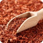 Pieces of sandalwood and fine sandalwood powder, evoking its earthy and luxurious nature